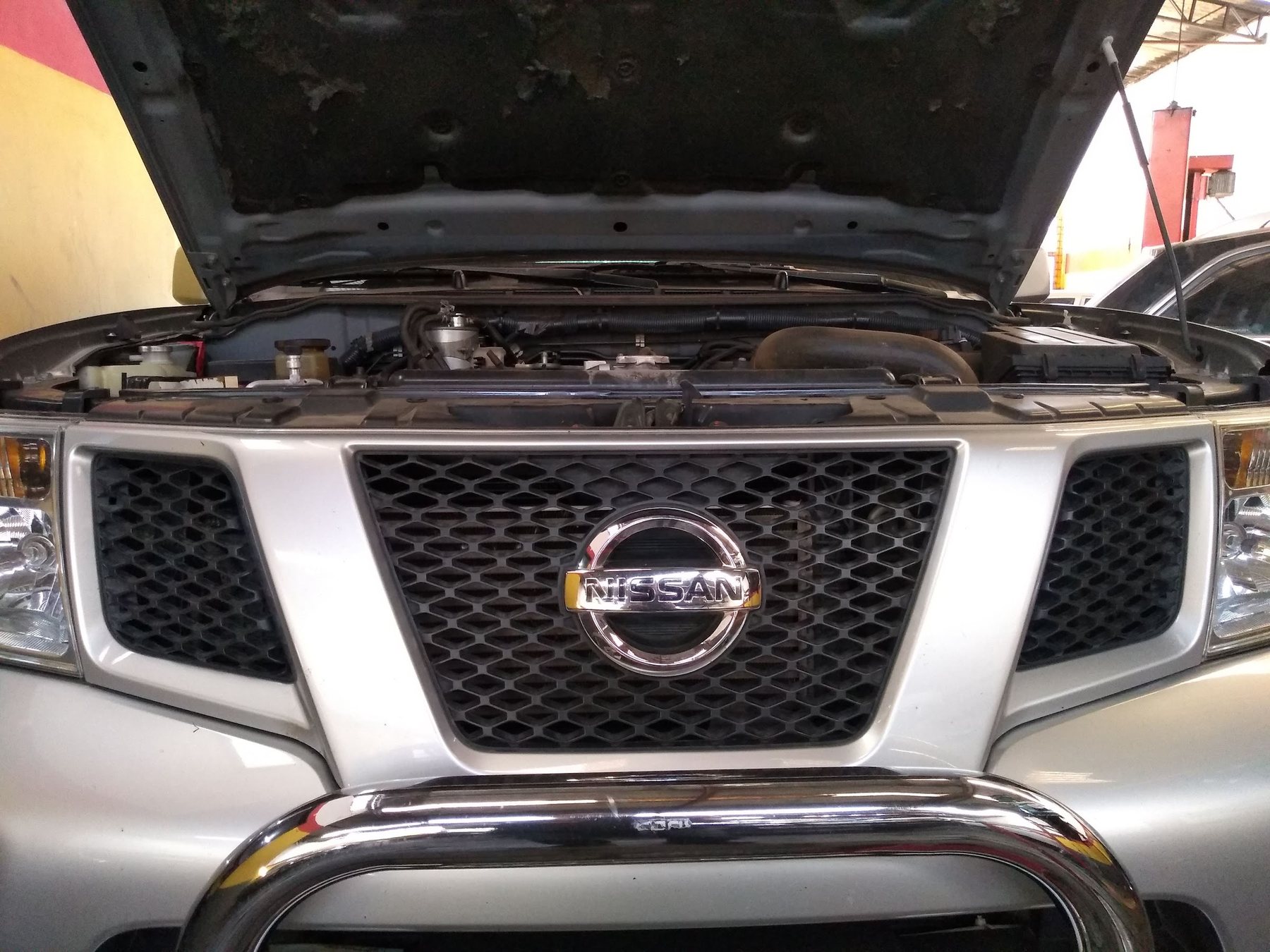 Nissan Frontier de capô aberto na oficina da Socar